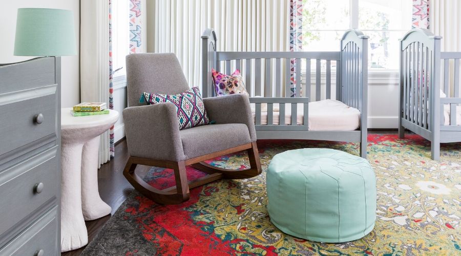 A nursery with Feizy rug, rocking chair and seafoam pouf