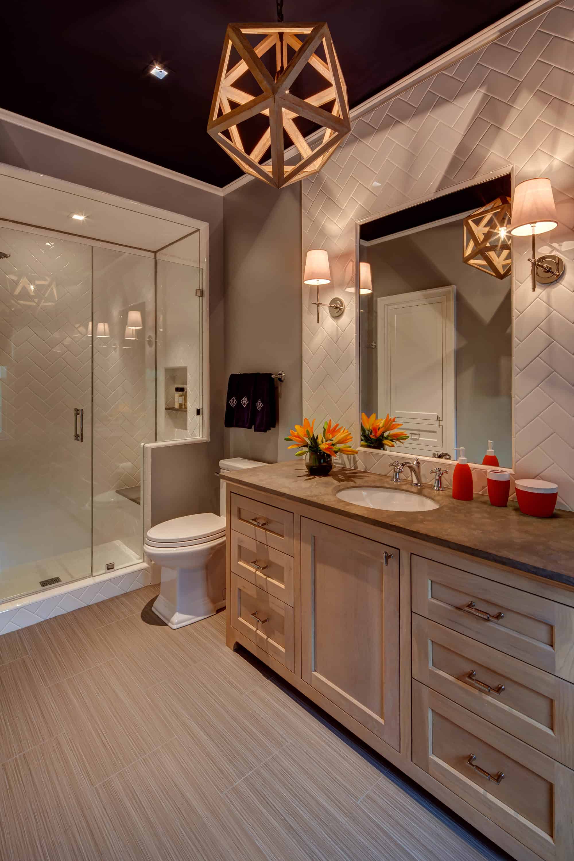 This dimly lit bathroom showcases a glass shower