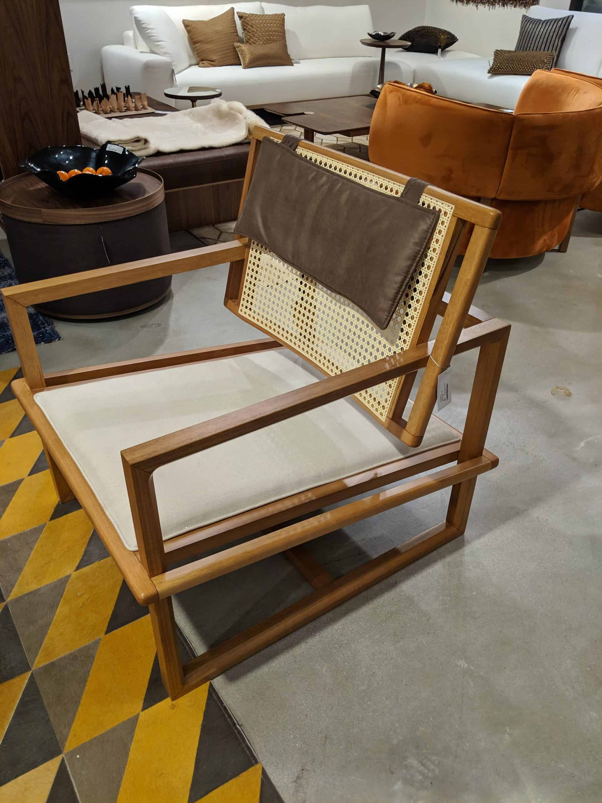 A chair featuring caning and leather straps at High Point Market 2019