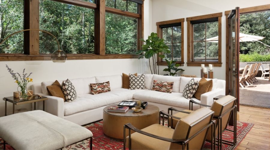 A bright, white living room in Aspen with plentiful seating and gorgeous windows