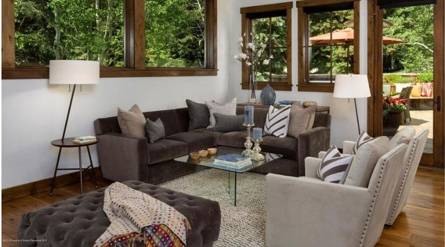 A living room in Aspen with L-shaped sectional, accent chairs and soft ottoman.