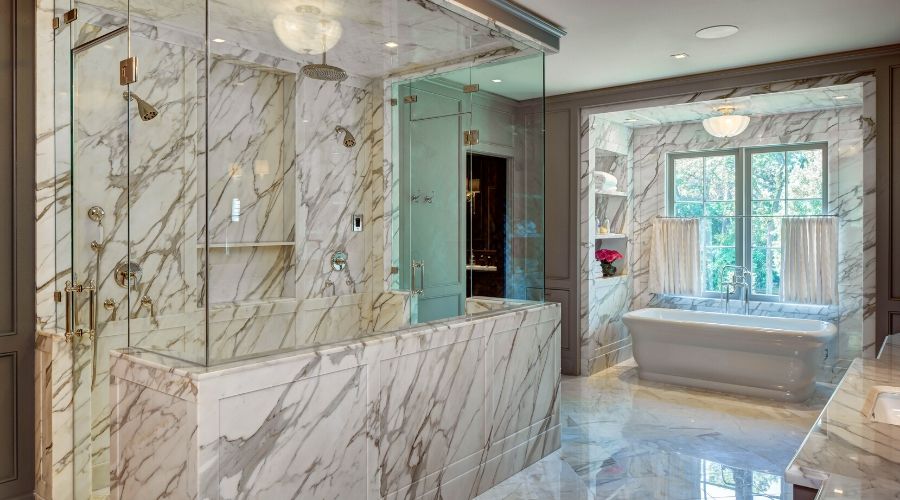 An elegant bathroom with wall-to-wall marble and enormous glass shower


