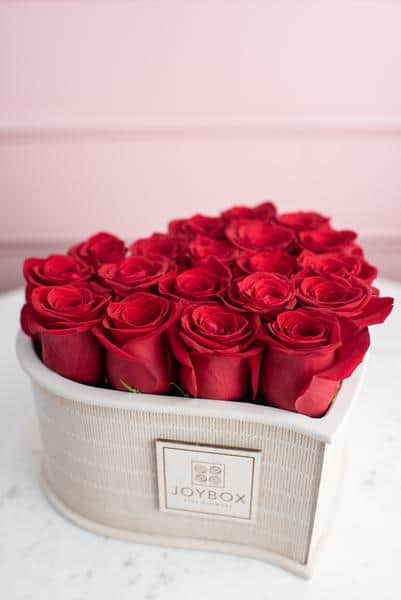 arrangement of red roses in a heart shaped container from JoyBox Flowers
