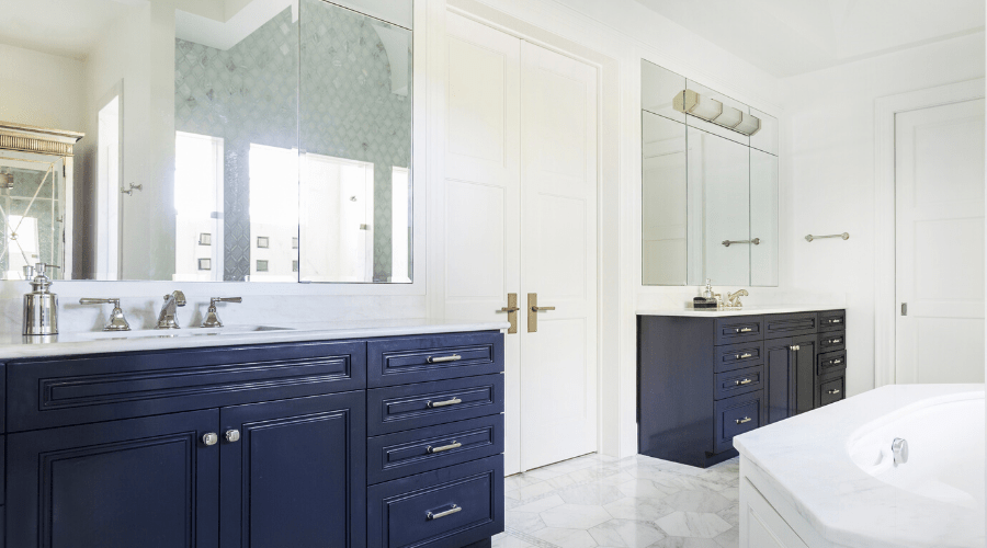 Blue cabinets contrast with white walls and honeycomb tile.