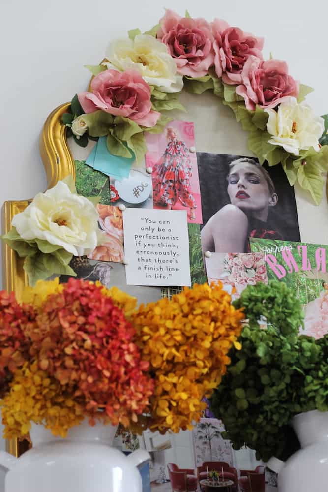 brightly colored flowers surrounding a gold framed pin board with inspiration images