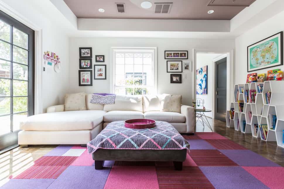Colorful kids playroom with bright rug and unique storage designed by Laura U Interior Design