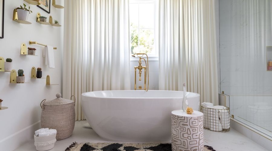 Custom drapery softens this spa-like bathroom with gold accessories