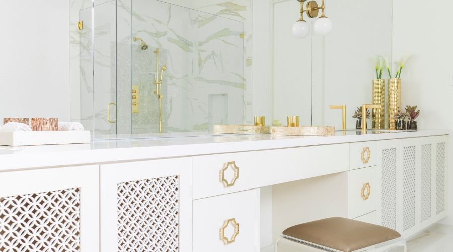 Gold accessories make this bright white bathroom a spa-like oasis