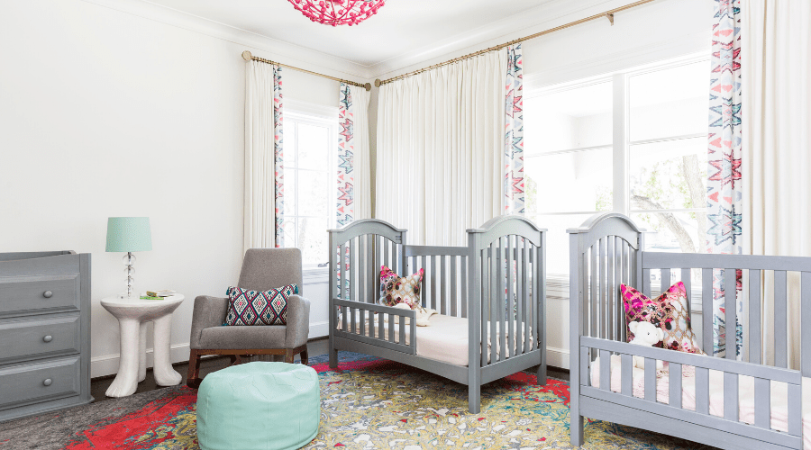 Gray hues found in the dresser, two cribs and rocking chair balance the room