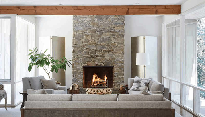 Modern living room interior design featuring stone fireplace and wood ceiling beams