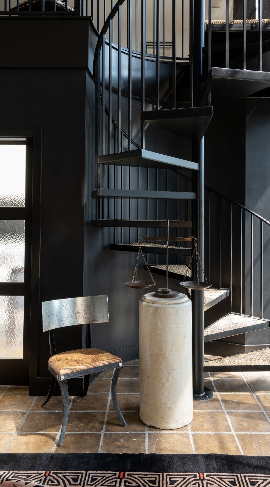 A spiral iron staircase winds towards the landing which features frosted doors that conceal a vibrant play room