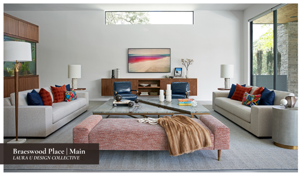 Contemporary living room featuring neutral sofas, blue leather chairs, a marble coffee table, and colorful accent pillows in a bright minimalist space.