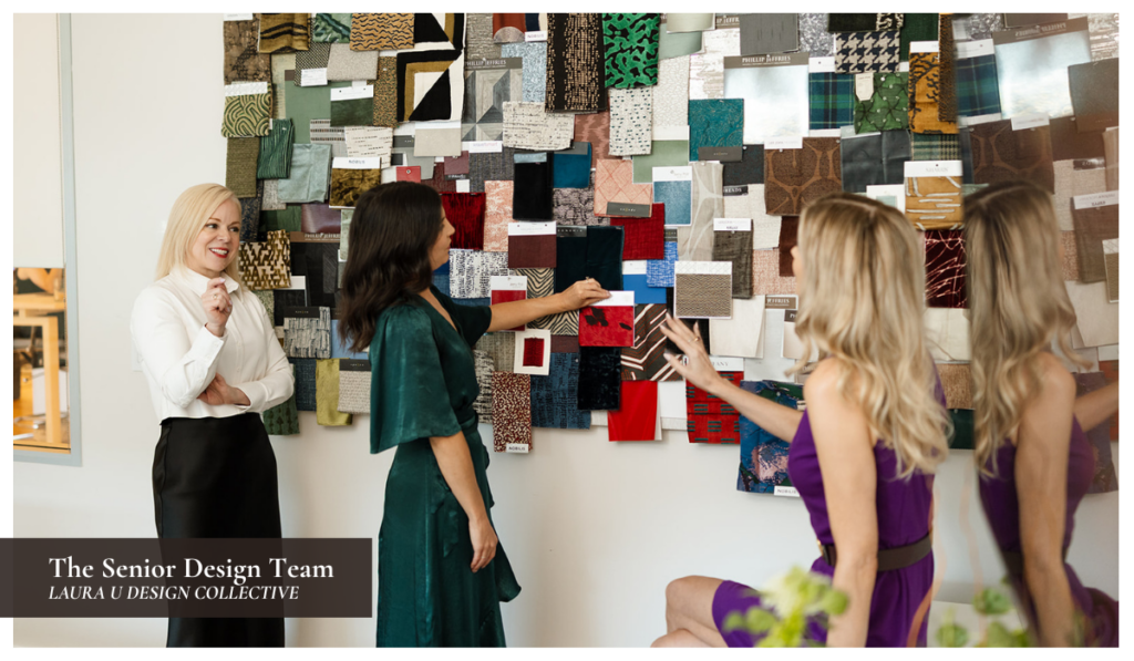 Interior designers reviewing fabric and material samples on a studio inspiration board during a collaborative design meeting.
