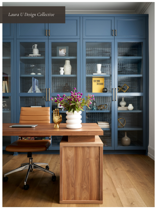 Warm home office design with a wood desk, comfortable leather desk chair, and blue built-ins for vertical storage. A great example of home office ideas that focus on natural light, stylish furniture, and maximizing workspace efficiency.