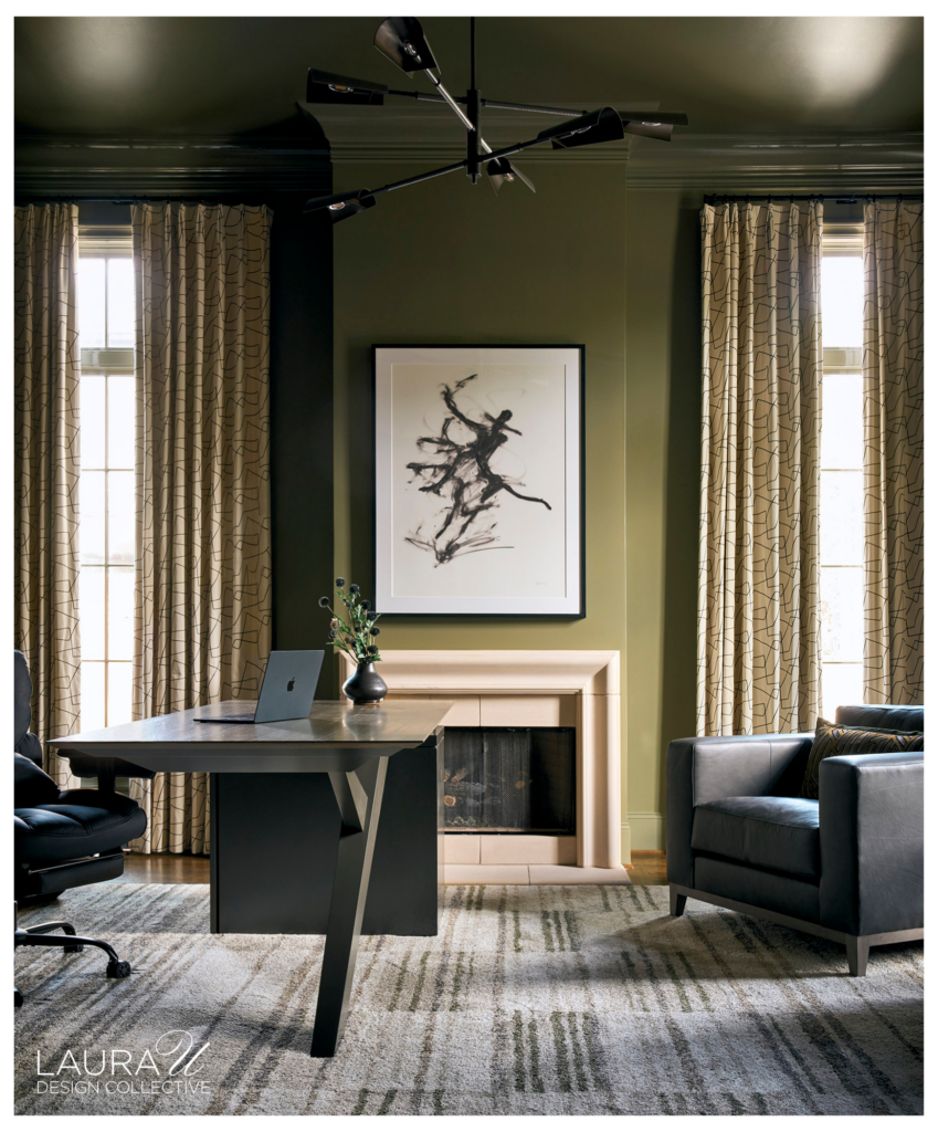 Deep green home office with matching walls and ceiling, patterned cream drapery, a black angular desk, leather seating, fireplace, and abstract artwork.
