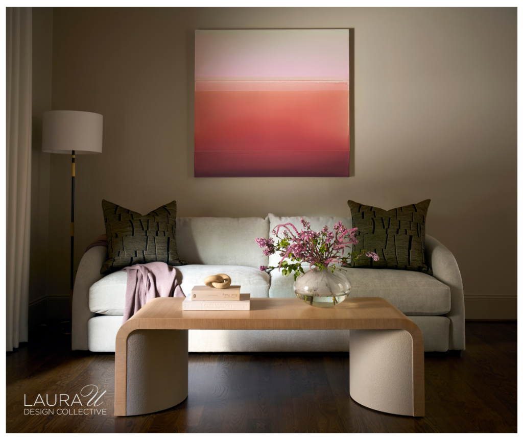 A seating area with bright pink artwork in the primary bedroom