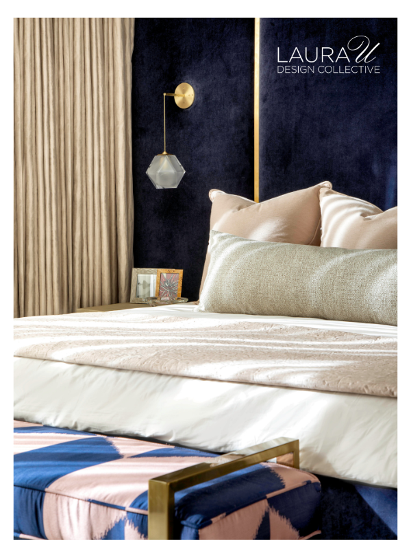 Bedroom with navy velvet wall panels, blush pillows, and a textured lumbar pillow on white bedding.