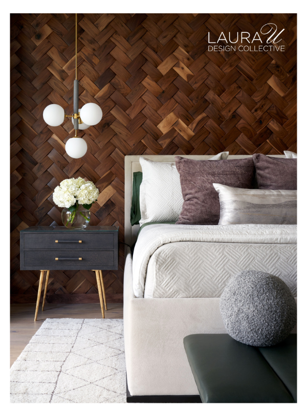 Bedroom with herringbone wood accent wall, upholstered bed, layered sleeping pillows, and mauve decorative pillows.