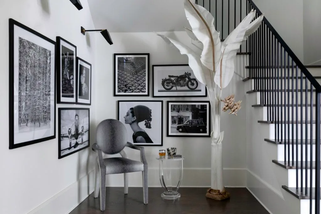 A gallery wall of black and white photos, artwork in a Houston home