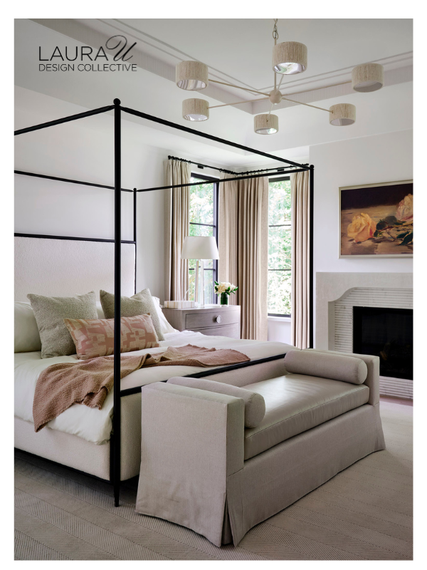 Neutral four-poster bed with layered sleeping pillows, decorative accent pillows, upholstered bench, and soft neutral furnishings.