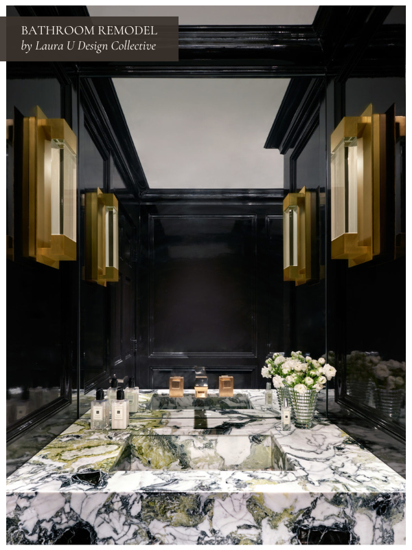 Elegant powder room with a dramatic black backdrop, gold wall sconces, and a marble-top vanity.