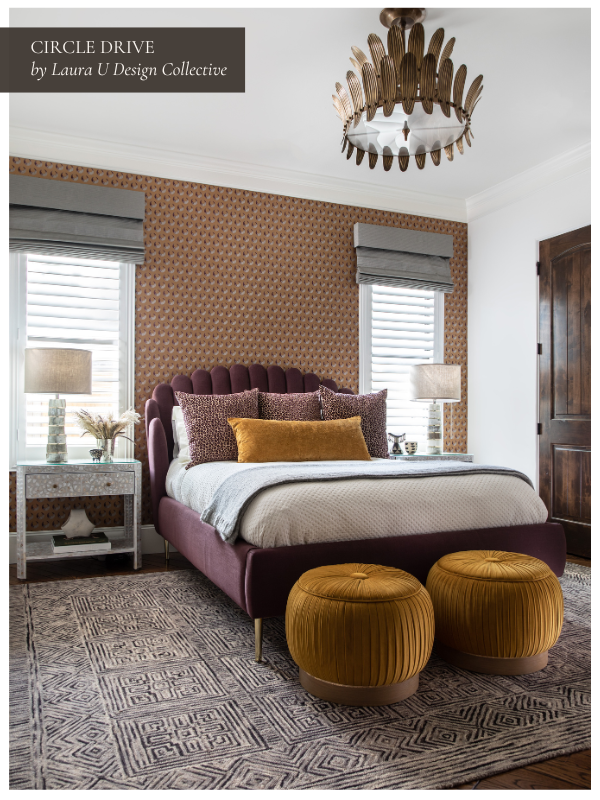 Warm, patterned bedroom featuring a plum bed frame, mustard ottomans, and geometric wallpaper.
