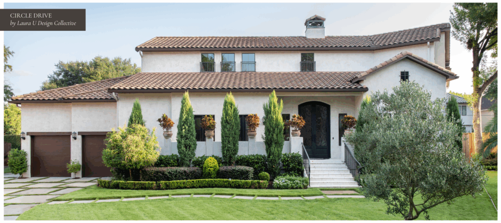 Front elevation of a Mediterranean-style home with a tiled roof, manicured hedges, and tall cypress trees framing the entryway