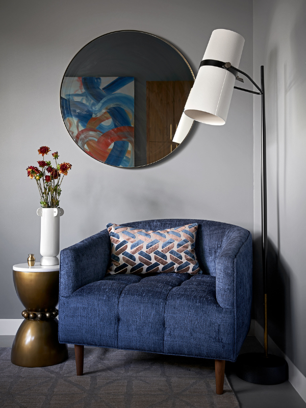 blue jewel tone chair with mirror and lamp
