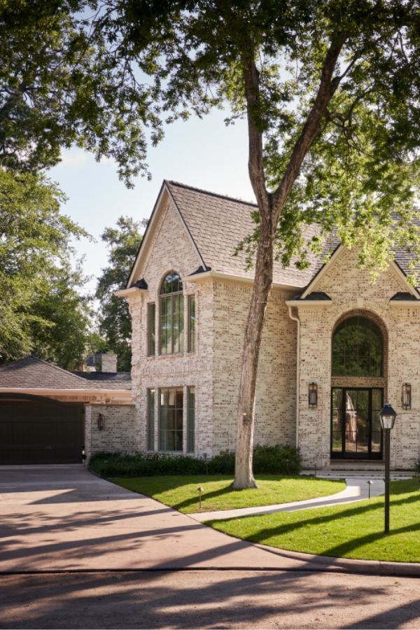 Balmore Residence exterior with white-washed brick and treelined street