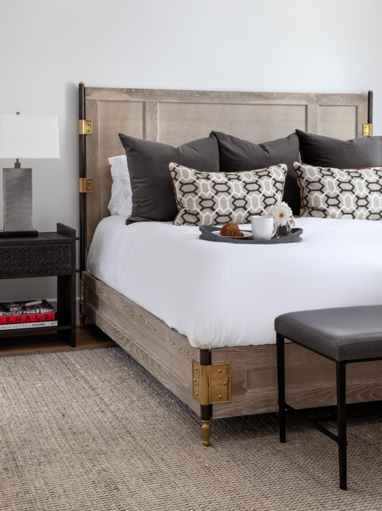 Guest bedroom design with rustic bed, grey & white pillows contrast each other well. 