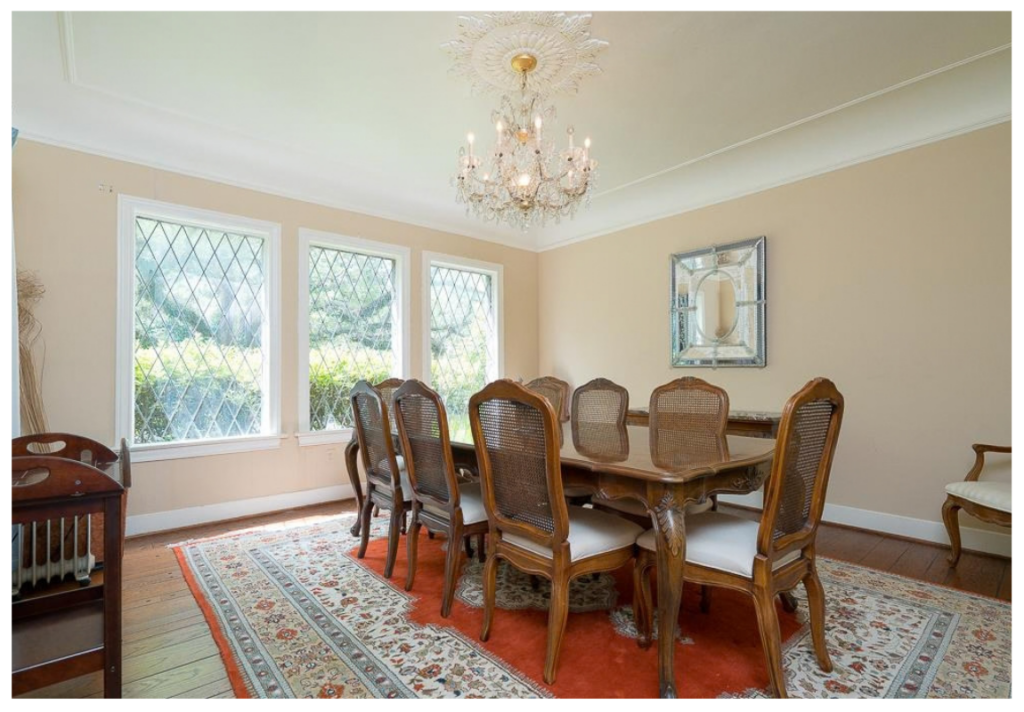 Traditional dining room before renovation with beige walls, diamond-pane windows, an antique wood table, and a crystal chandelier.