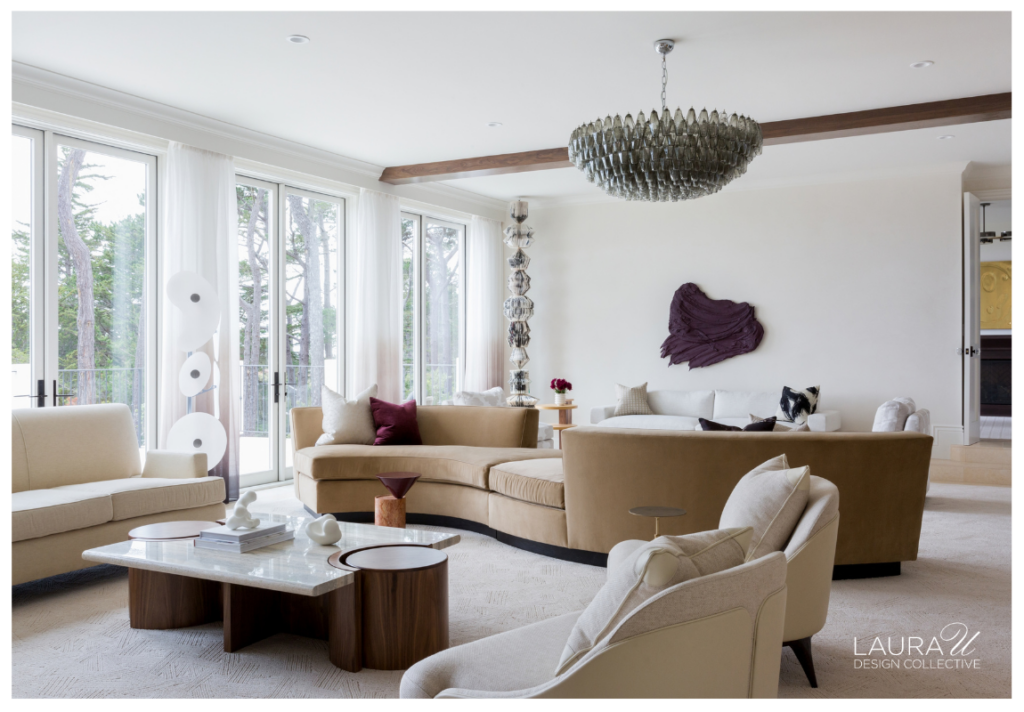 Pebble Beach living room with curved neutral sofas, a sculptural glass chandelier, large windows, and contemporary artwork.
