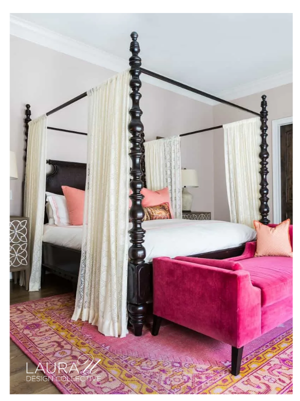 Traditional wood bed beneath exposed beams with white sleeping pillows and a floral bolster pillow.